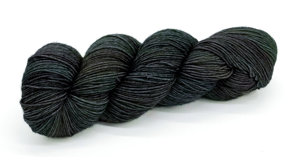 A skein of yarn with dark rustic greens and deep river blues.