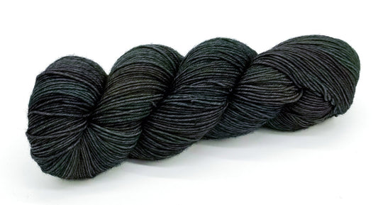 A skein of yarn with dark rustic greens and deep river blues.
