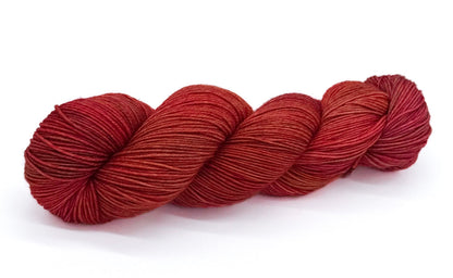 A skein of yarn featuring rosewood, ember and sunset copper tones.