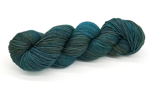 A skein of yarn with seafoam teal, ocean mist and dusky tidepool greens.