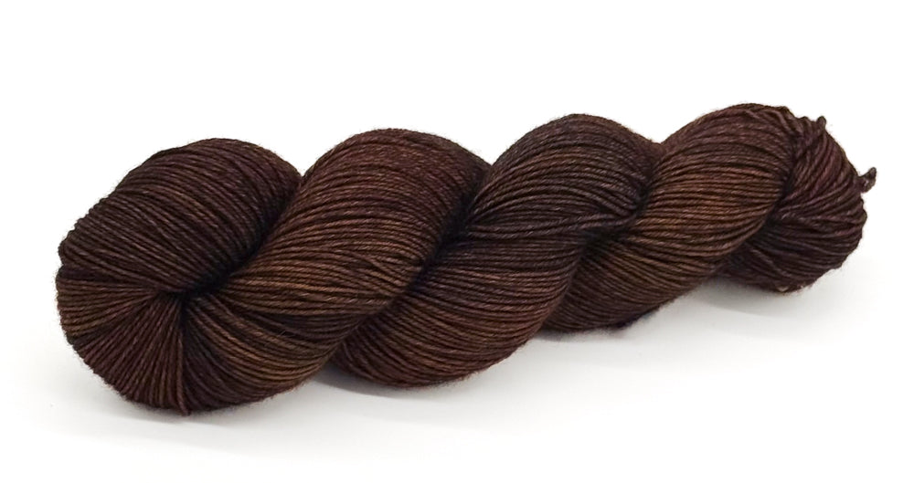 A skein of yarn in warm sepia browns with subtle gold and walnut undertones.