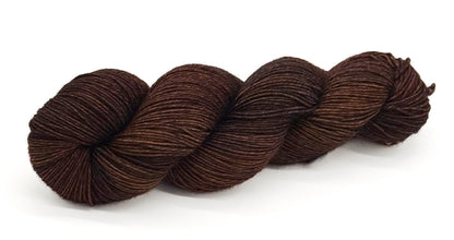 A skein of yarn in warm sepia browns with subtle gold and walnut undertones.