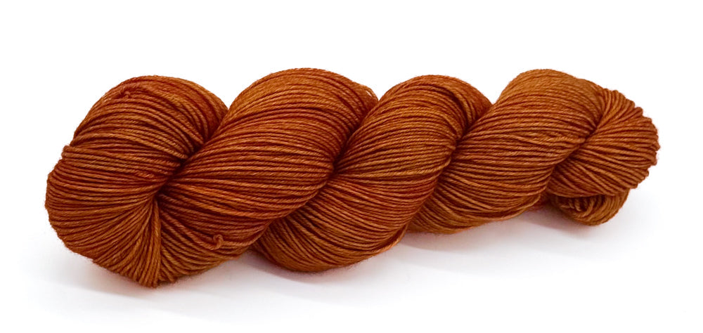 A skein of yarn glowing in golden ochre and tangerine shades.