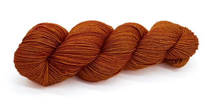 A skein of yarn glowing in golden ochre and tangerine shades.