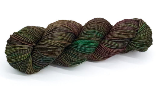 A skein of yarn combining mossy greens with hints of burgundy and teal.