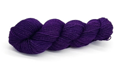A skein of yarn in rich violet and twilight purple tones.